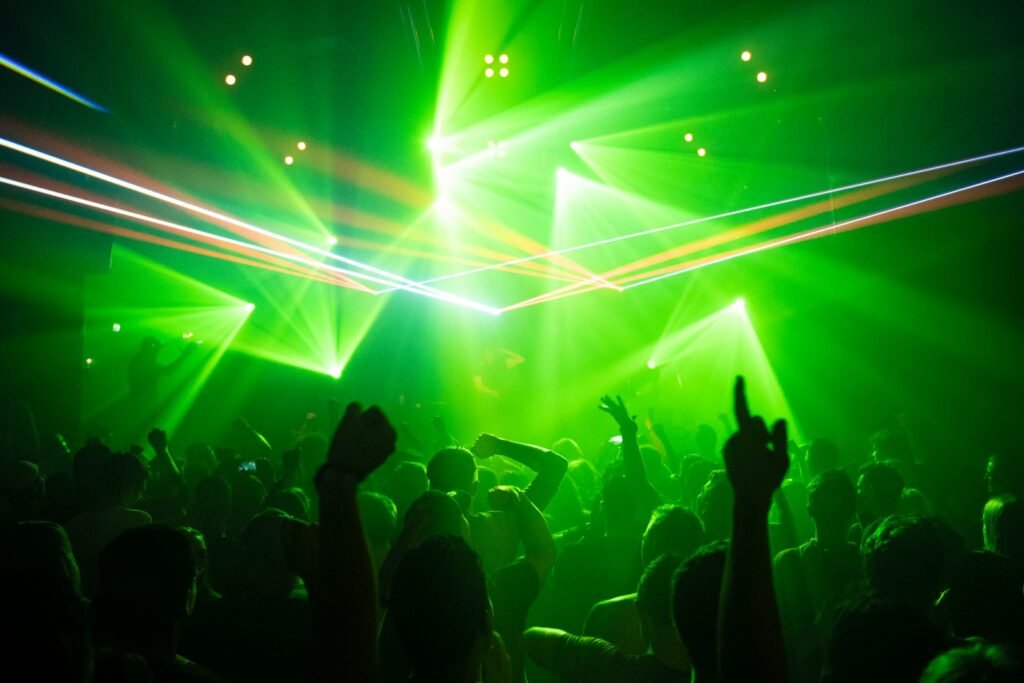 People dancing in a club under green lights