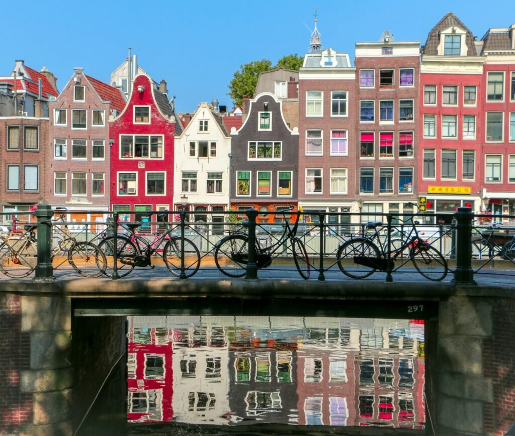 Historic canal houses in Amsterdam with bicycles parked on a bridge