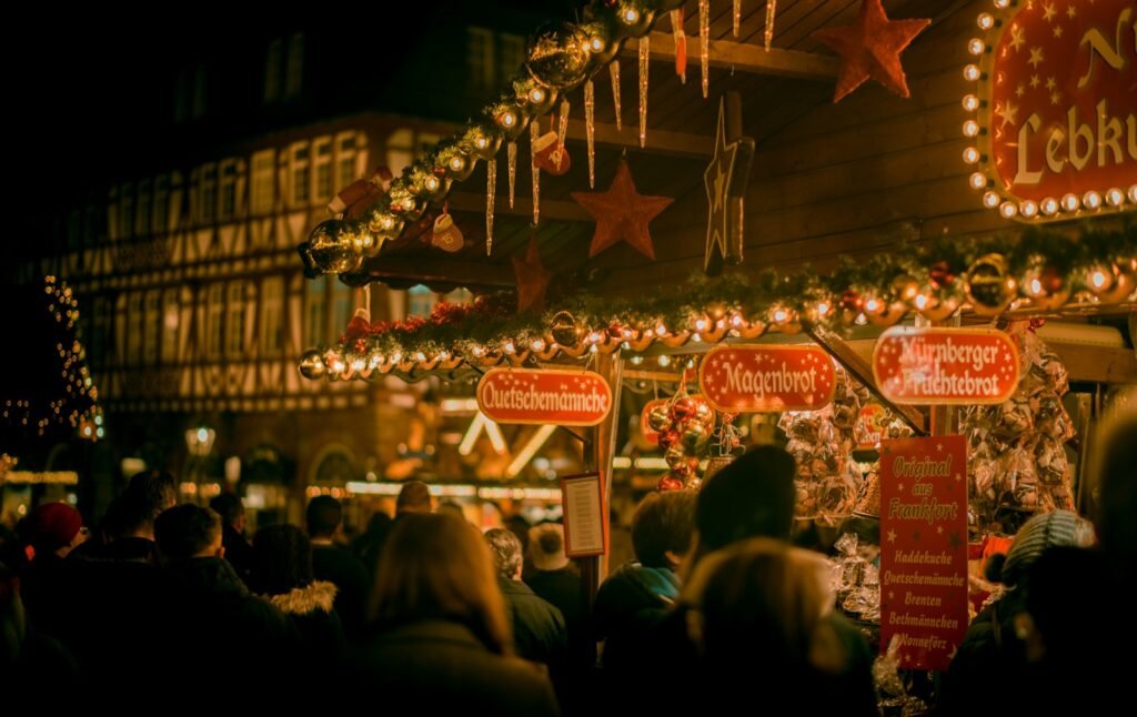 People browsing stalls at a Christmas market at night