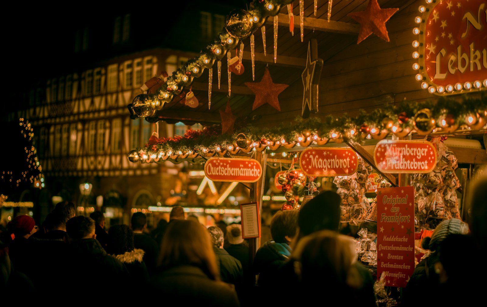 People browsing stalls at a Christmas market at night