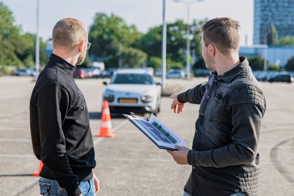 Driving examiner with a clipboard pointing at a car during a driving test