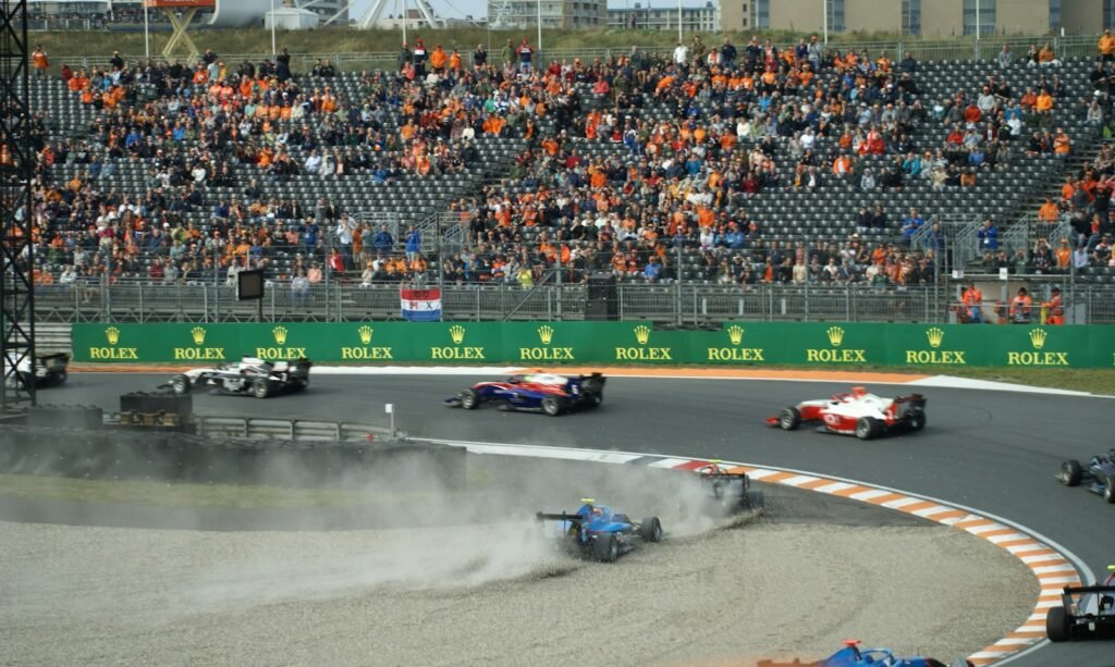 Formula 1 cars racing at Circuit Zandvoort in front of a packed grandstand