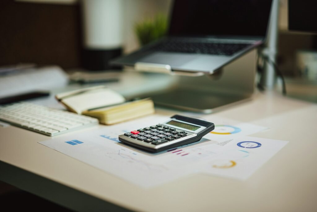 A calculator next to a laptop