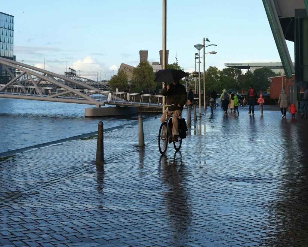 Man cycling on a wet street on a rainy Dutch winter day