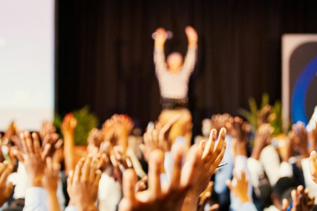 Festival crowd raising their hands under colorful lights