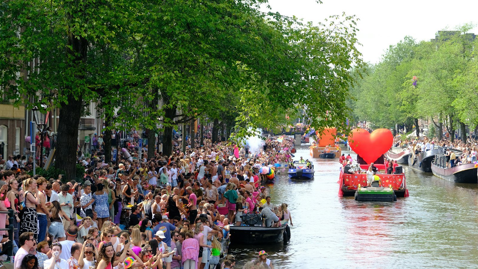 Crowd watching a boat on an Amsterdam canal