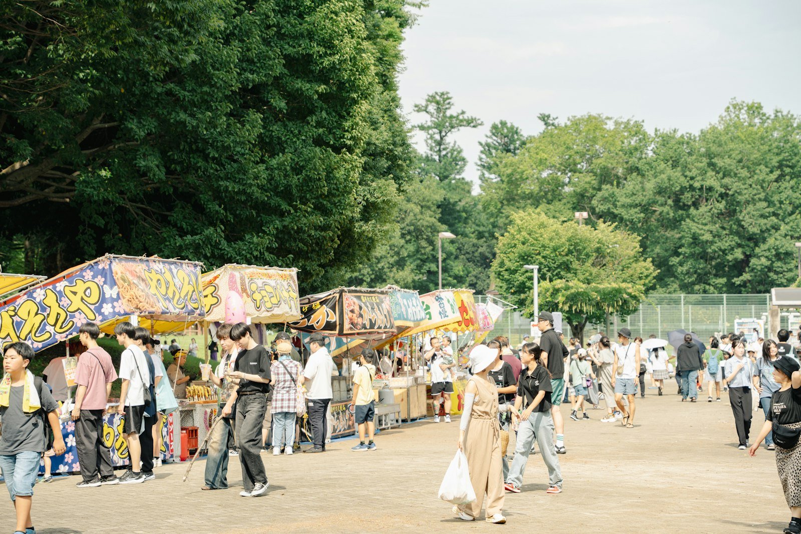 People walking past food stalls at an outdoor festival