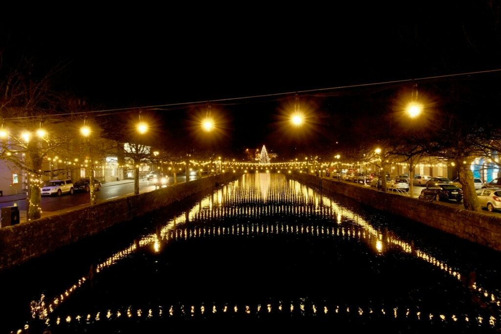 Canal reflecting lights at night in a town