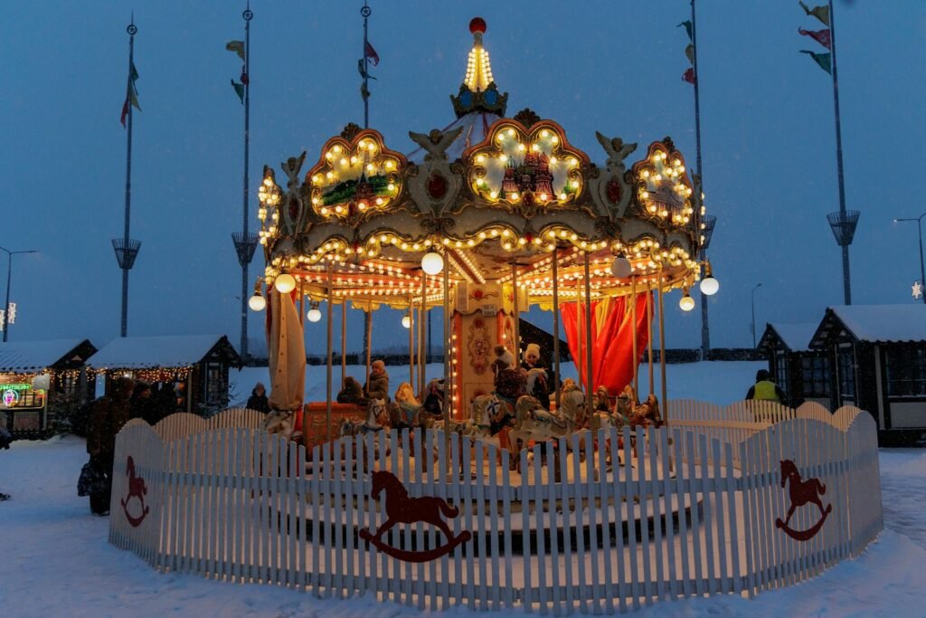Brightly lit carousel in the snow at dusk