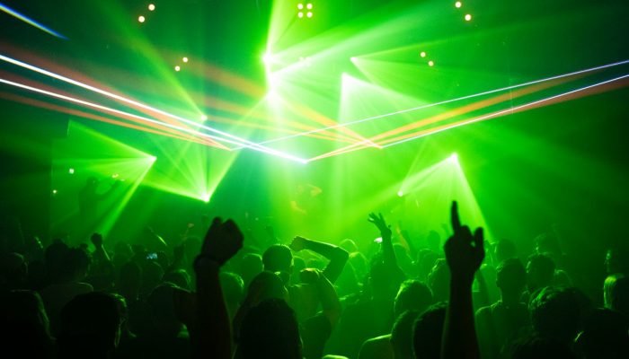 People dancing in a club under green lights