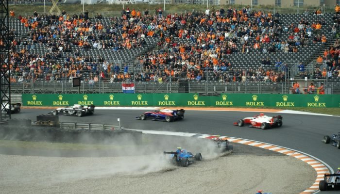 Formula 1 cars racing at Circuit Zandvoort in front of a packed grandstand