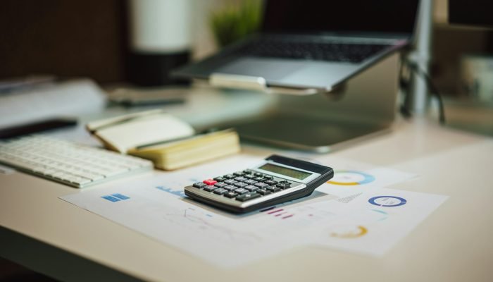 A calculator next to a laptop