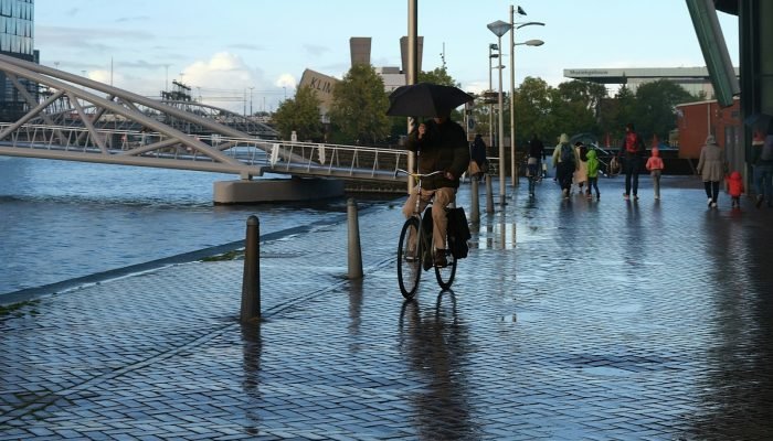 Man cycling on a wet street on a rainy Dutch winter day