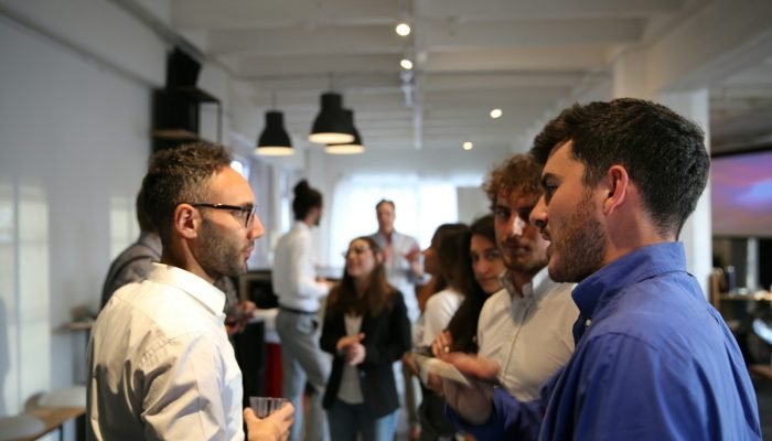 A group of people talking at an indoor event
