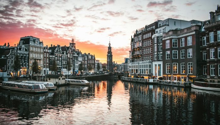 A boat on a canal between Dutch canal houses